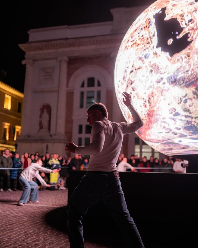 Dei ballerini danzano di fronte alla Biosfera di Pesaro mentre l'installazione digitale risponde ai movimenti percepiti