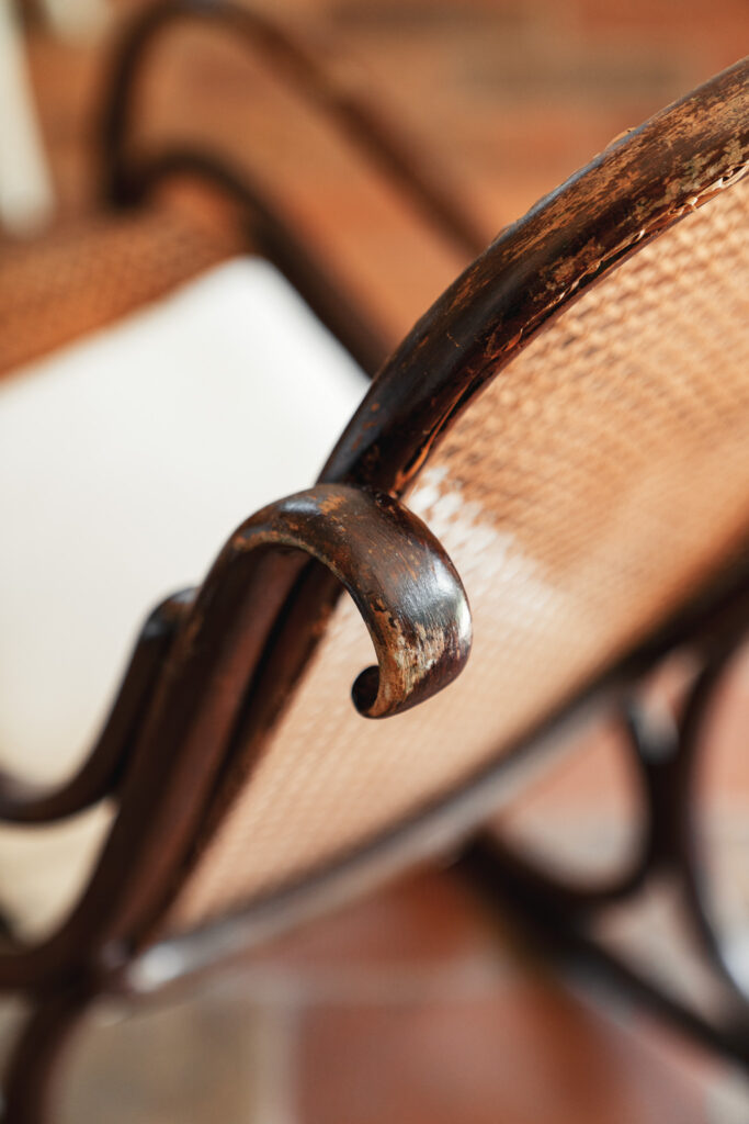 Particolare del legno antico di una chaise longue in un ambiente luminoso.