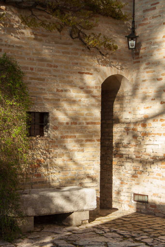 An arched doorway connects the chapel to Il Pignocco farmhouse.
